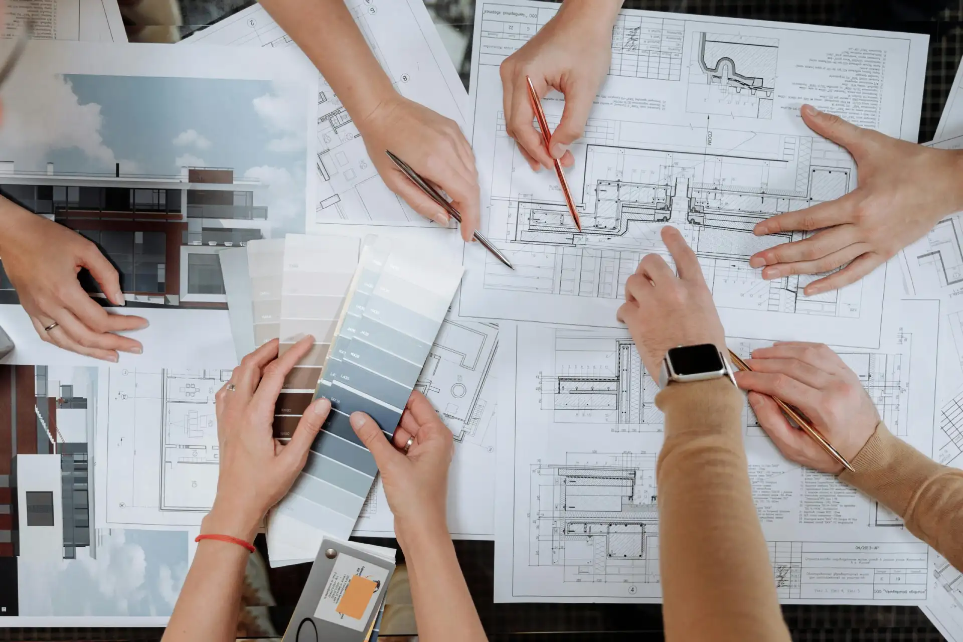 GCI Construction large image with hands pointing to architextual plans